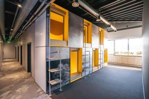 a hallway of an office building with yellow doors and shelves at Light House Coliving in Klaipėda