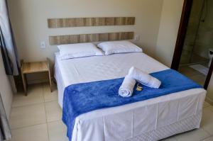 a bedroom with a bed with two towels on it at Pousada Vila Regina in Penha