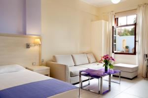 a hotel room with a bed and a couch at Giorgi's Blue Apartments in Kalathas