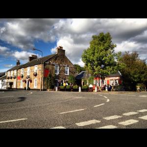 an old building on the side of a street at The Original Rosslyn Inn in Roslin