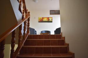 a staircase with chairs and a painting on the wall at Apartments Center GSV in Puerto Villamil