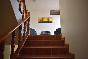 un escalier avec des chaises et un tableau sur le mur dans l'établissement Apartments Center GSV, à Puerto Villamil