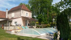 a swimming pool in front of a house at Maison COMAYOU in Loubieng