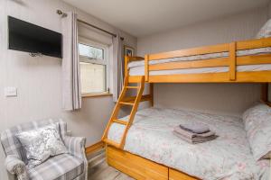 sypialnia z łóżkiem piętrowym, telewizorem i krzesłem w obiekcie Annslea w mieście Lisburn