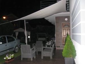 韋巴的住宿－Willa Aura，庭院配有椅子和遮阳伞,还拥有一个汽车