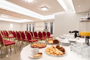 a conference room with a long table with plates of food at Heliotrope Hotels in Mytilini