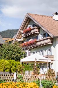 un edificio con flores en los balcones y una sombrilla en Appartement Haidacher en San Candido