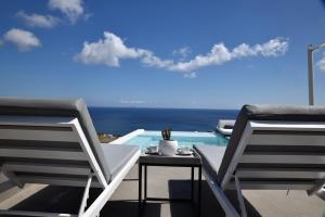 a patio with a table and chairs next to a pool at Horizon Mills in Imerovigli