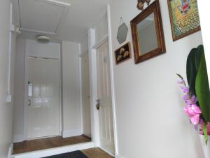 a hallway with white walls and a mirror on the wall at Shalom in Longford
