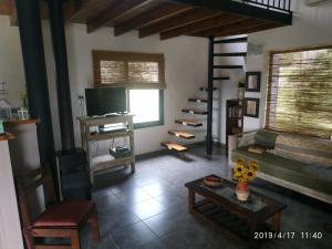 a living room with a couch and a tv at Las Golondrinas in Tandil