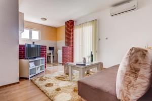 a living room with a couch and a television at Libra Apartments in Tivat