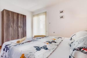 a bedroom with a bed with a comforter with butterflies on it at Libra Apartments in Tivat