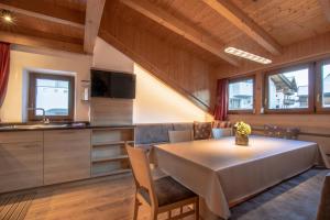 een keuken en eetkamer met een tafel en stoelen bij Appartamenti Vilin in San Cassiano