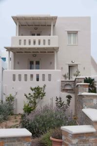 uma casa branca com uma cerca à frente. em Villa Adriana Hotel em Agios Prokopios