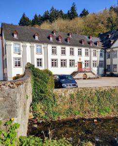 un gran edificio blanco con un coche aparcado delante de él en Gästehaus der Abtei Sayn, en Bendorf