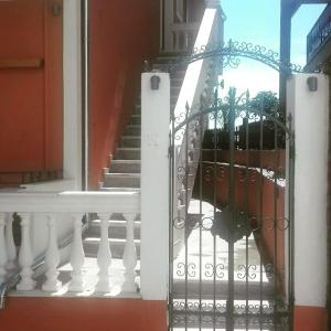 une porte blanche en face d'une maison avec des escaliers dans l'établissement Sunrise House, à Parga
