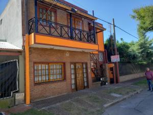 un edificio naranja con un balcón en la parte superior. en Complejo La Naranjita en Rosario