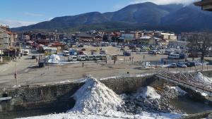 a city with a parking lot with snow on the ground at Koko's apartments in Bansko