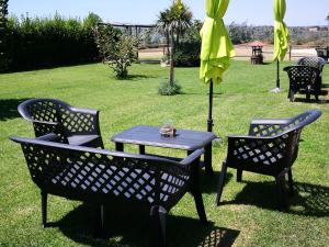 2 Stühle und ein Tisch mit gelbem Regenschirm in der Unterkunft Agriturismo La Valle Dell'Albegna in Orbetello
