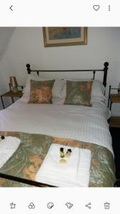 a picture of a bed with two towels on it at White Horse Inn in Andover