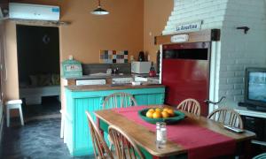 una cocina con una mesa con un bol de fruta. en La Posada de Agustina en Tandil