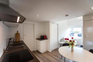 een keuken met een vaas met bloemen op een tafel bij New Point in Zandvoort +17 foto's