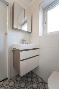 een badkamer met een wastafel en een spiegel bij New Point in Zandvoort