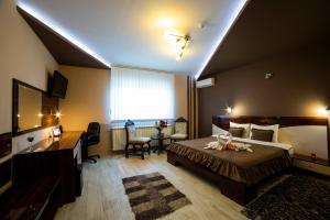 a hotel room with a large bed and a desk at Garni Hotel Lama in Kragujevac