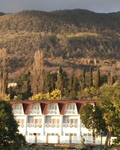 un grand bâtiment blanc avec un toit rouge dans l'établissement Palm Hotel, à Nouvel Athos