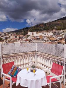 a table with two glasses of wine on a balcony at PLAZA NUEVA in Sierra Nevada