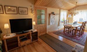 a living room with a flat screen tv and a table at Iverhjelen Near Atlantic Road in Lyngstad