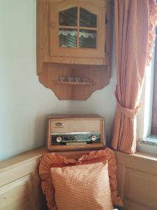 une ancienne radio assise à côté d'une armoire et d'un oreiller dans l'établissement Montafon Alpen Chalet, à Vandans