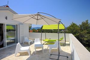 a patio with a table and chairs and an umbrella at Apartments Vila Moli in Bibinje