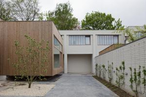 a white brick house with a garage at Hotel Wu Wei in Kortrijk