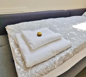 a bed with white towels and a ring on it at Casa Muro in Friedrichshafen