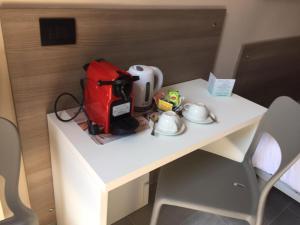 a white desk with a bag and cups on it at Aparthotel San Gregorio 45 in Milan