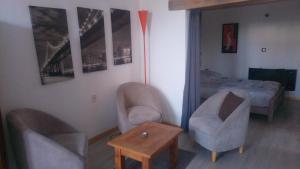 1 dormitorio con 2 sillas, 1 cama y 1 sombrilla de color naranja en Le gite au tilleul en Vauhallan
