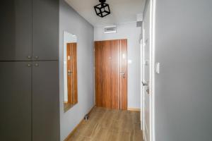 a room with a hallway with a wooden door at Apartament Dla Ciebie in Olsztyn