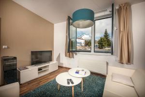 un soggiorno con divano, TV e tavolo di Apartment No. 11, Apartment House Oliver a Štrbské Pleso