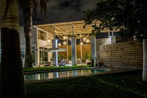 ein Haus mit Sonnenschirm und Pool bei Nacht in der Unterkunft Hotel Avenida en Arica in Arica + 33 Fotos