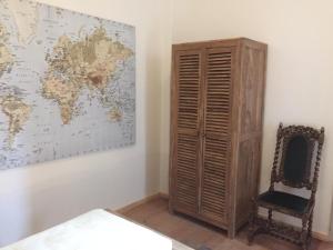 a room with a wooden cabinet and a world map on the wall at Rathaus-Pension 1685 in Brandenburg an der Havel