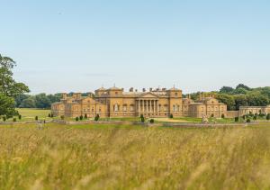 a large mansion in a field of grass at Victoria in Holkham