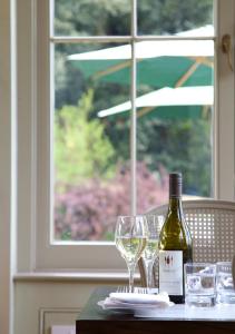 a bottle of wine sitting on a table with glasses at Victoria in Holkham