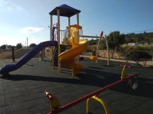 a playground with a slide at Sunset Guest House in Kormakiti