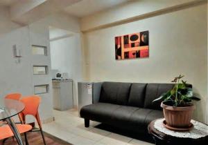 sala de estar con sofá negro y mesa en Minimalist Department, en La Paz