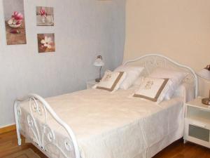 ein weißes Bett mit zwei Kissen darauf im Schlafzimmer in der Unterkunft Holiday Home O'Petit Bonheur by Interhome in Langlerial