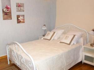 un letto bianco con due cuscini sopra in una camera da letto di Holiday Home O'Petit Bonheur by Interhome a Langlerial