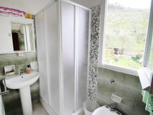 ein Bad mit einem Waschbecken und einer Dusche mit einem Fenster in der Unterkunft Apartment Cristina by Interhome in Bracco