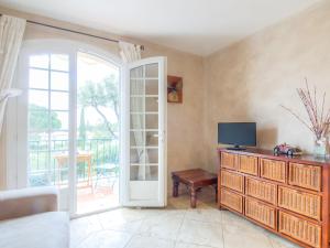 - un salon avec une télévision et une porte coulissante en verre dans l'établissement Apartment Les Carles by Interhome, à Saint-Tropez
