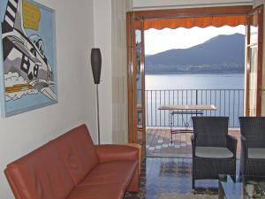een woonkamer met een bank en uitzicht op het water bij Apartment Residenza del Pascià by Interhome in Oggebbio